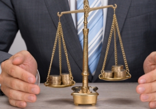 Product transfer sector a big opportunity for advisers in 2018: FSE Manchester pound coins money scales balance business man hands